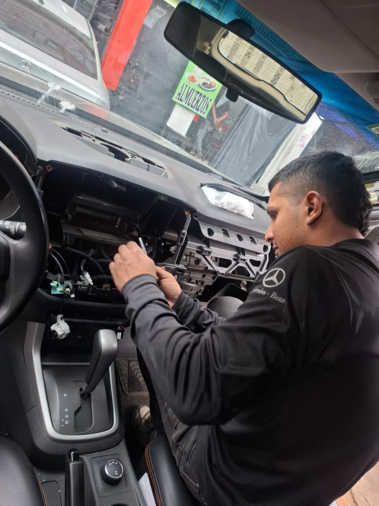 Técnico realizando cambio de cintilla de airbag en volante de vehículo